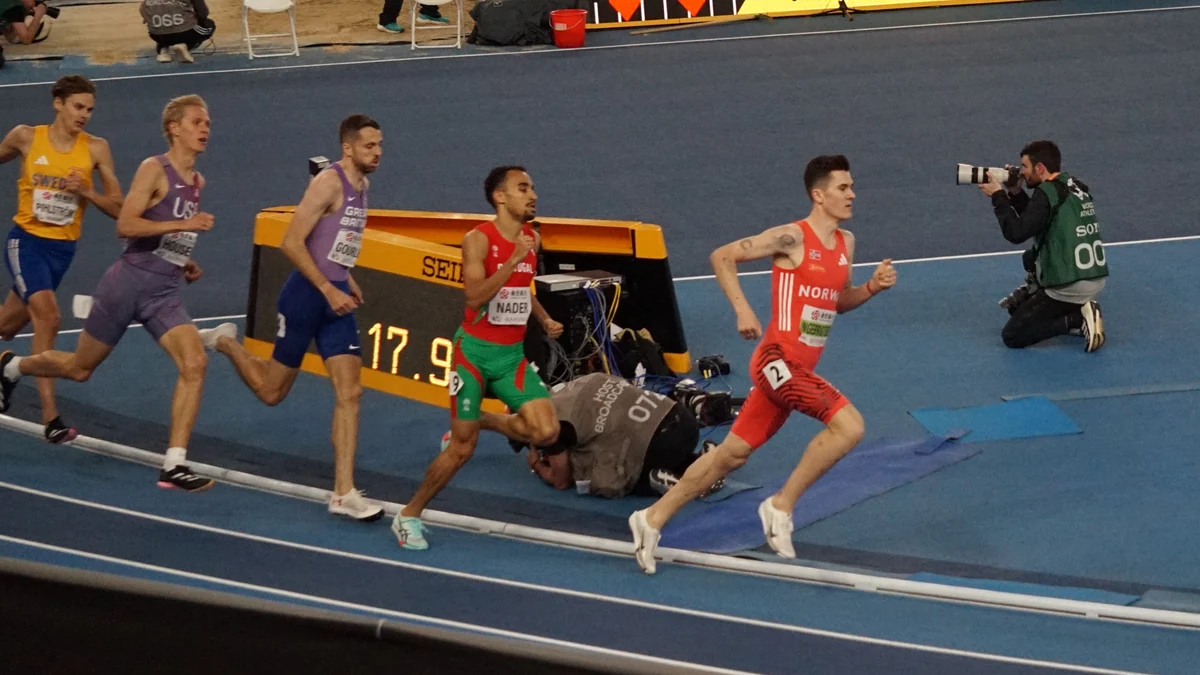 Jakob Ingebrigtsen, wearing Norway’s red uniform, leads runners on a blue track.