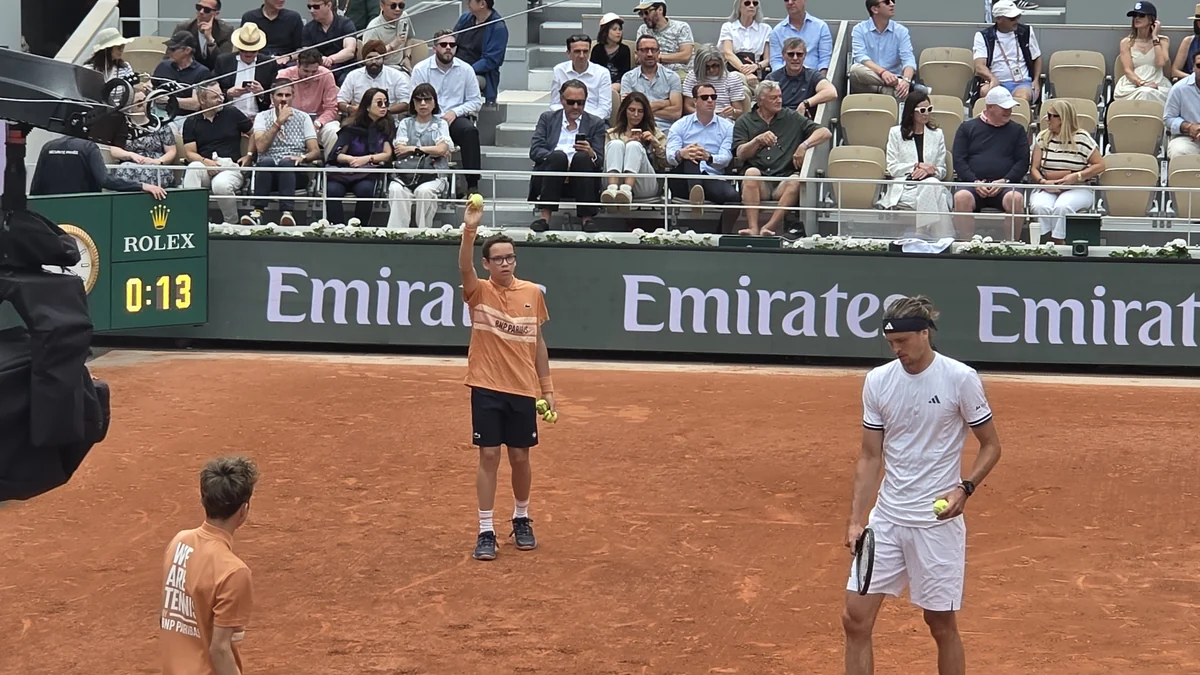 Alexander Zverev segura raquete e bola em uma quadra de saibro diante das arquibancadas