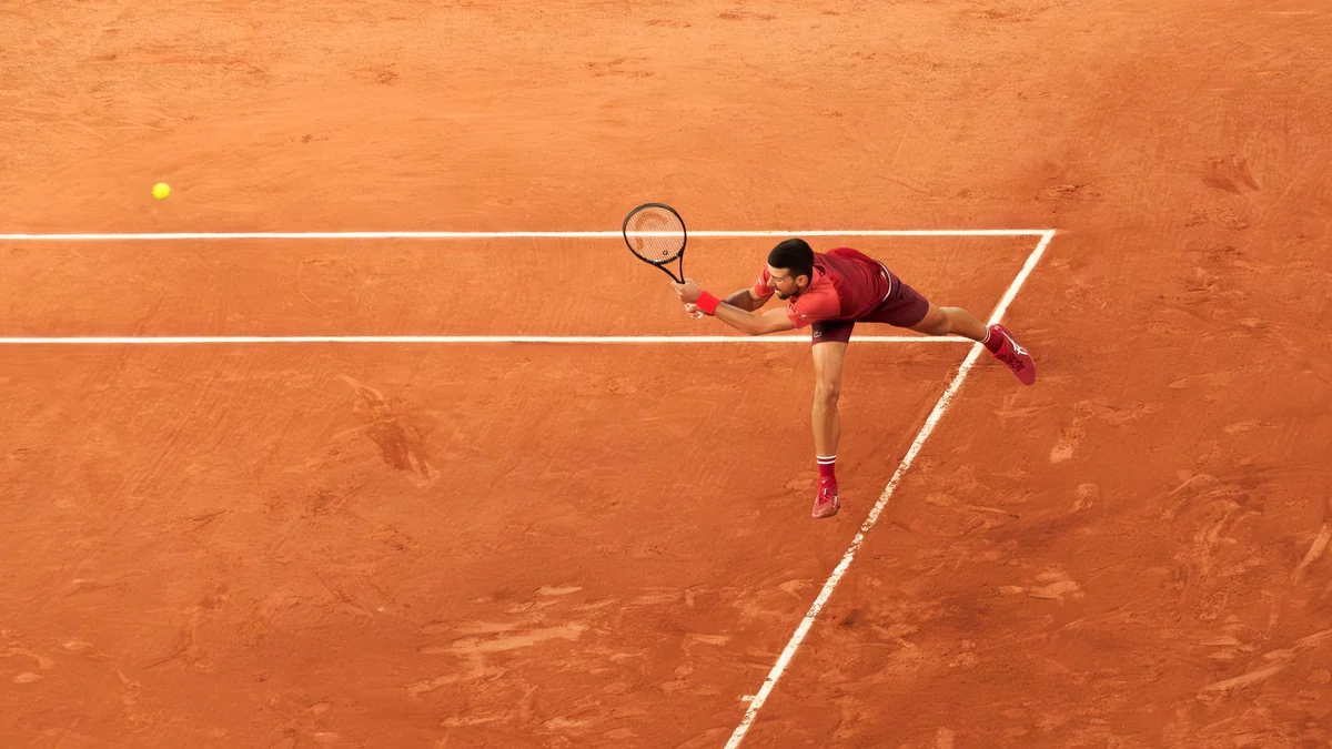 Novak Djokovic se détend pour atteindre la balle sur un court en terre battue