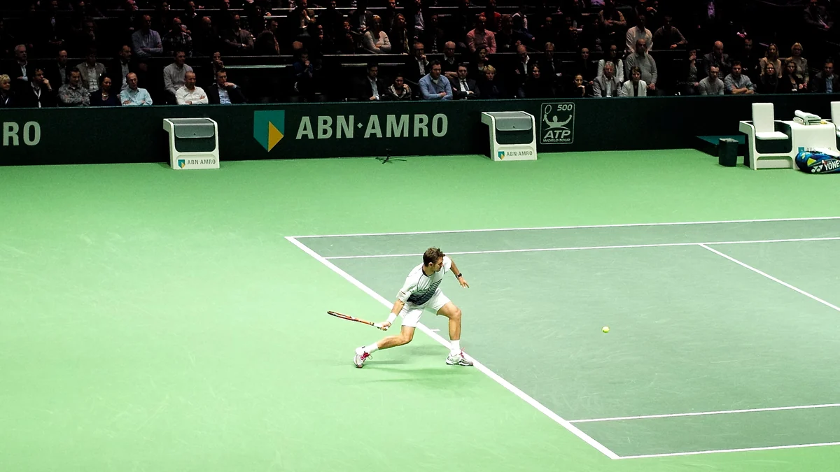 Stan Wawrinka moves to return a ball on an indoor tennis court.
