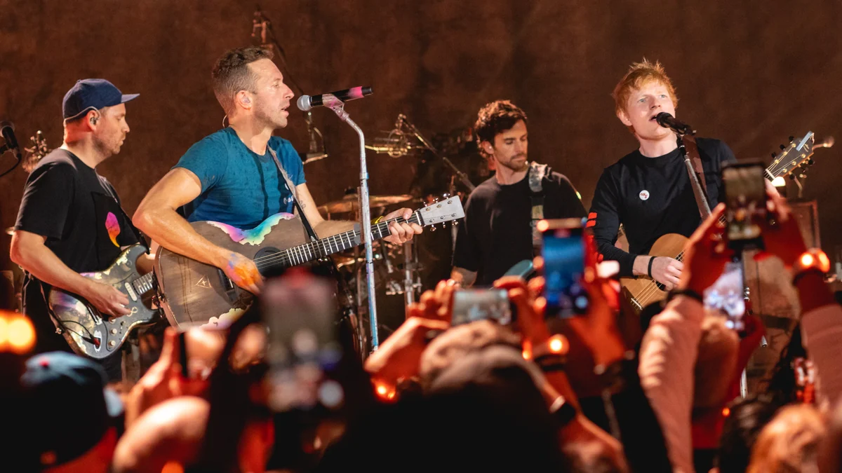 Ed Sheeran toca violão e canta ao lado de integrantes do Coldplay diante do público