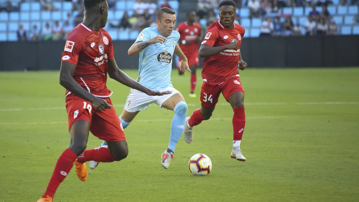 Un joueur du Celta de Vigo conduit le ballon entre deux adversaires de Mayence 05