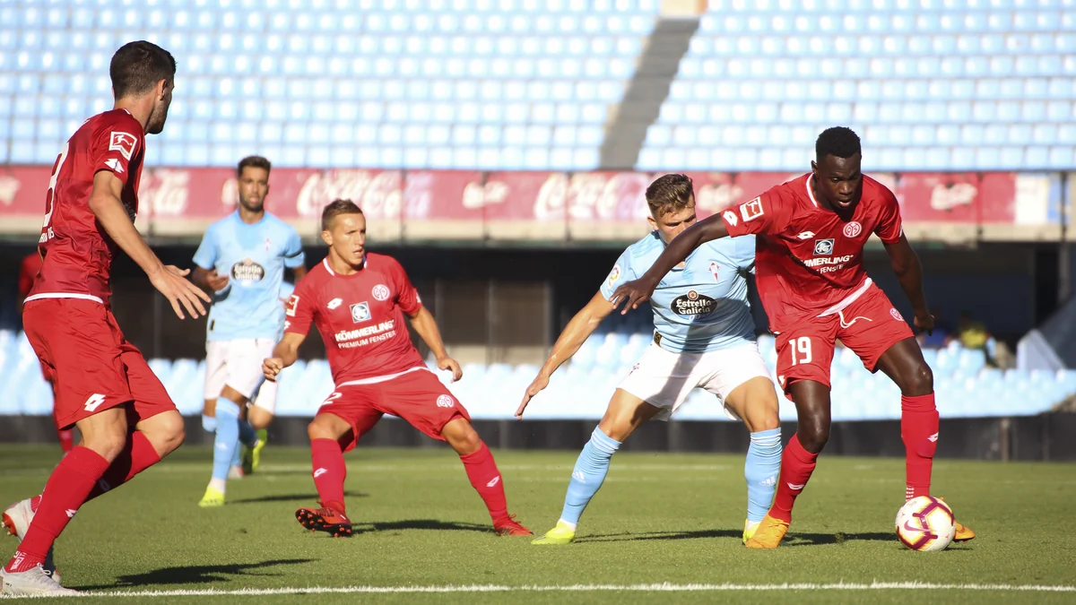 Un joueur de Mayence 05 protège le ballon face à un joueur du Celta de Vigo en bleu ciel