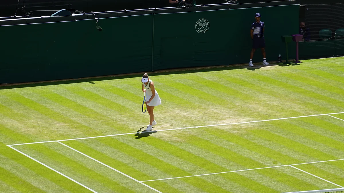 Elise Mertens lanza la pelota para sacar sobre una pista de hierba