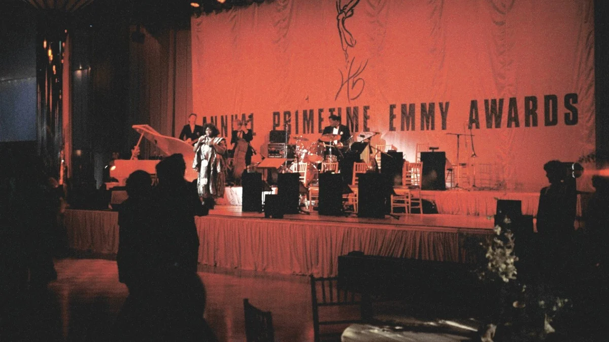 Palco com a inscrição Primetime Emmy Awards, instrumentos musicais e pessoas em primeiro plano