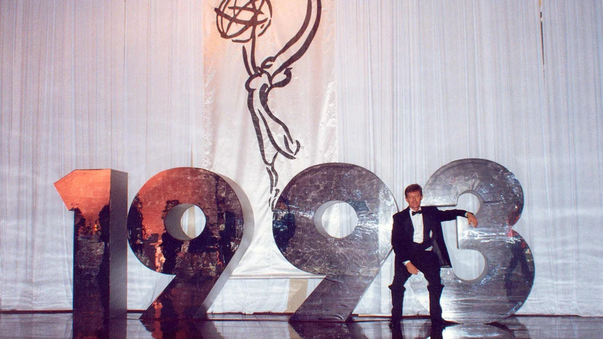 Homem de smoking ao lado de grandes algarismos de 1993 sob o desenho de uma estatueta do Emmy
