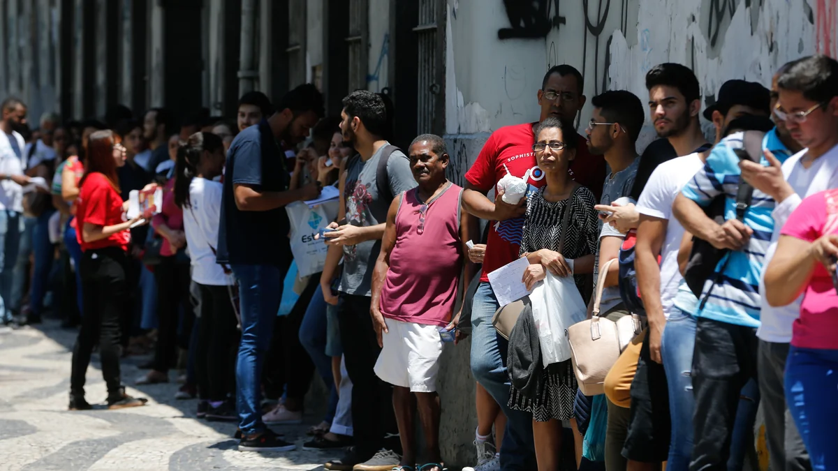 File de personnes le long du mur extérieur d’un centre d’examen