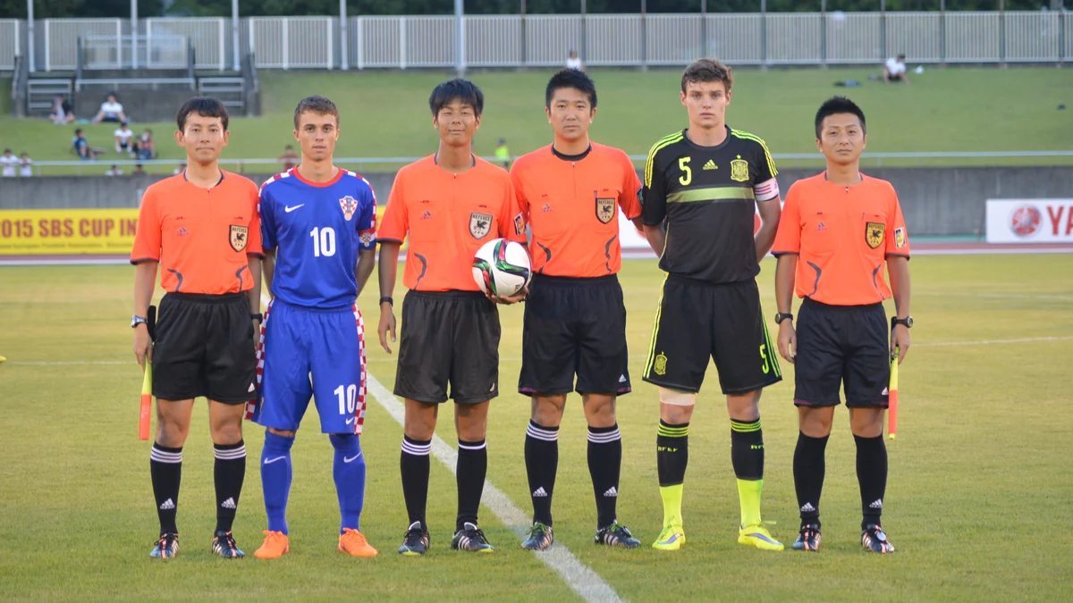 Croatia and Spain captains standing with the referee team on a football pitch