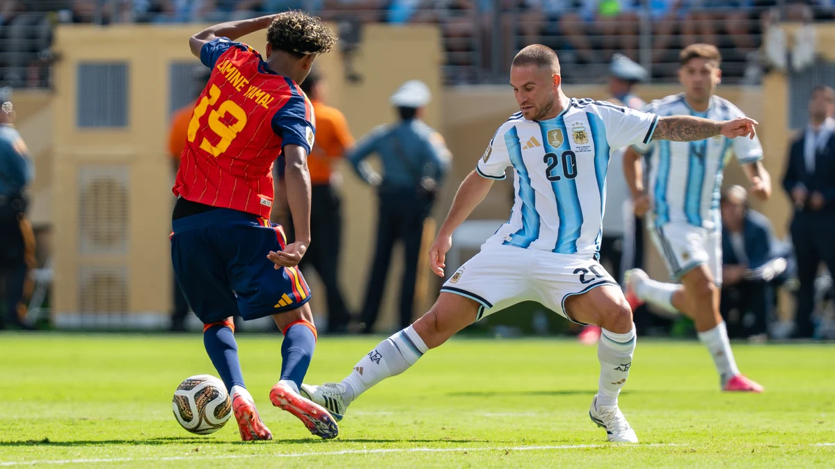 Lamine Yamal, seen from behind in Spain’s number 19 shirt, controls the ball against an Argentina player