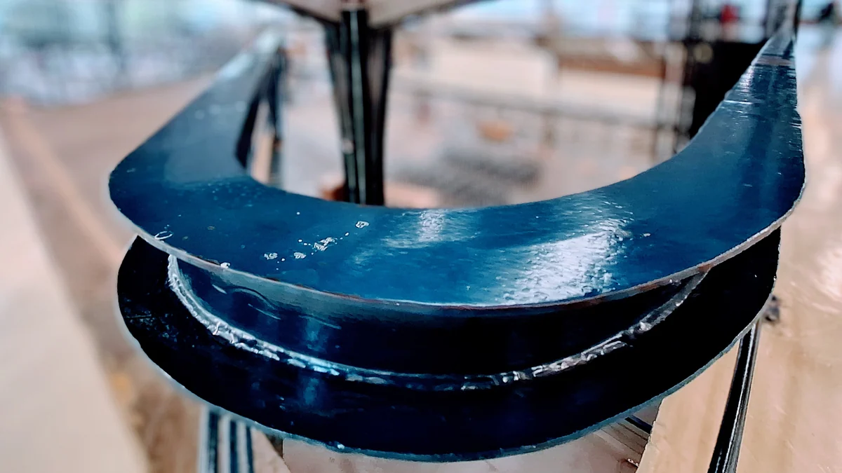 Curved blue element in the foreground, with railings and a blurred CCSP interior behind it.