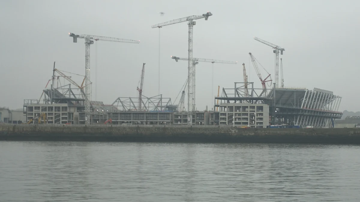 Stade d’Everton en construction parmi des grues, vu depuis l’autre rive par temps brumeux