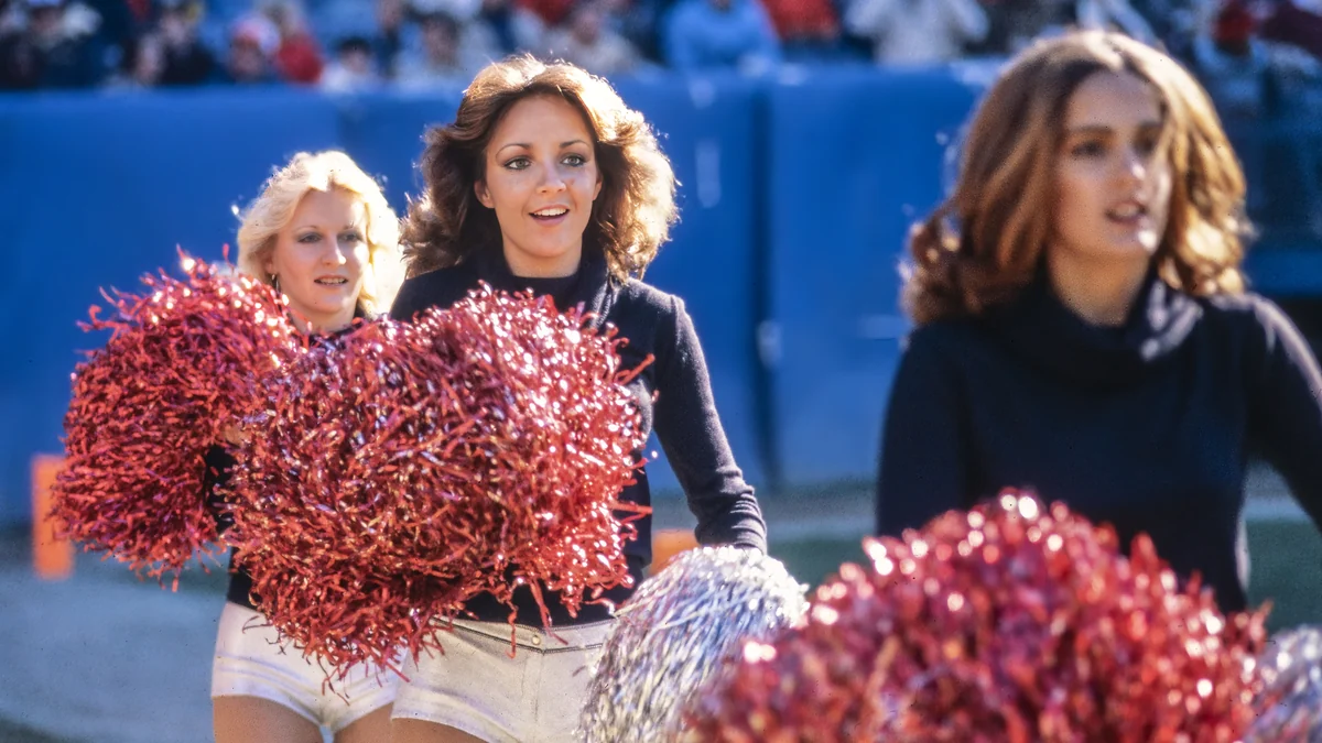 Animadoras de los Atlanta Falcons con pompones rojos y plateados junto al campo