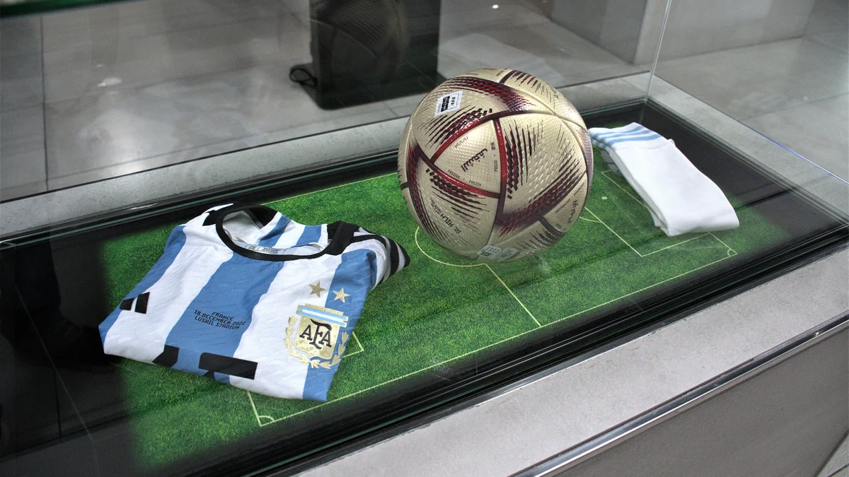 Camiseta de la selección argentina, balón de fútbol y medias dentro de una vitrina