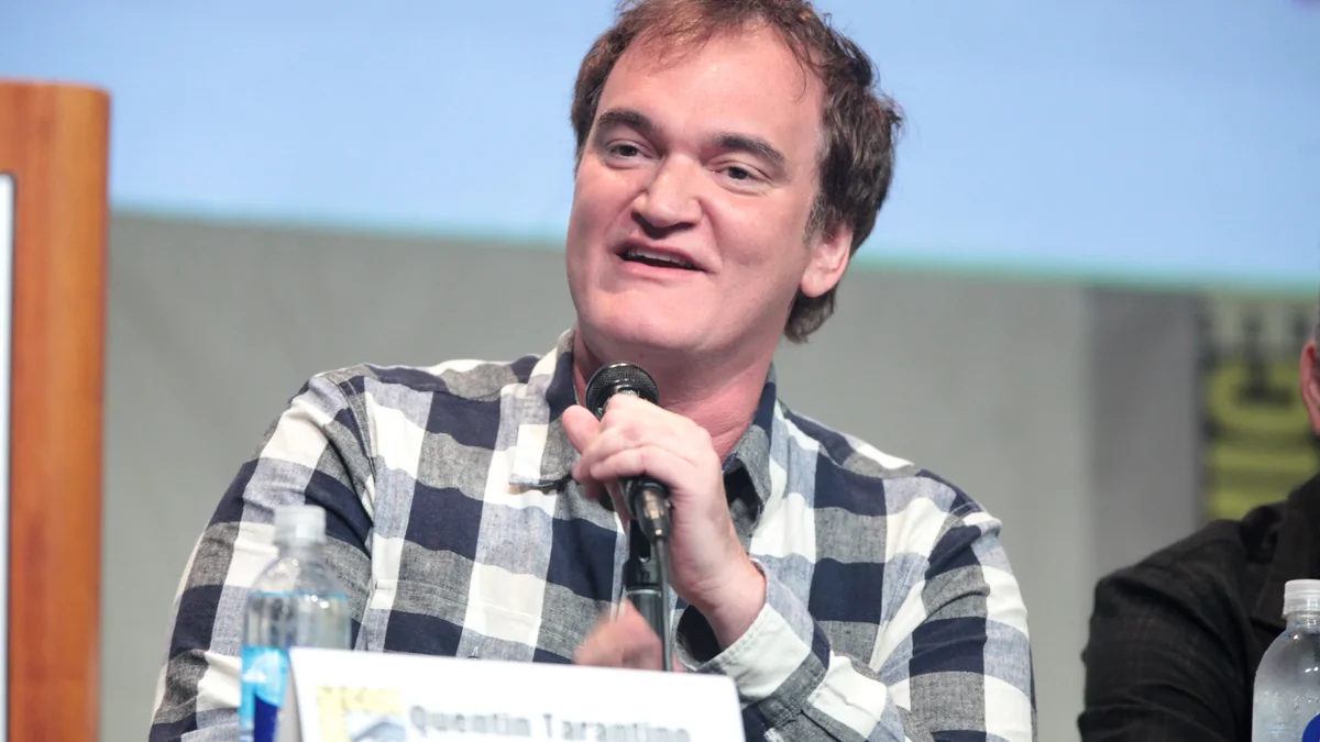 Quentin Tarantino segura um microfone durante uma conversa pública.