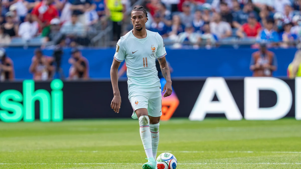 Michael Olise conduit le ballon avec la tenue claire numéro 11 de la France