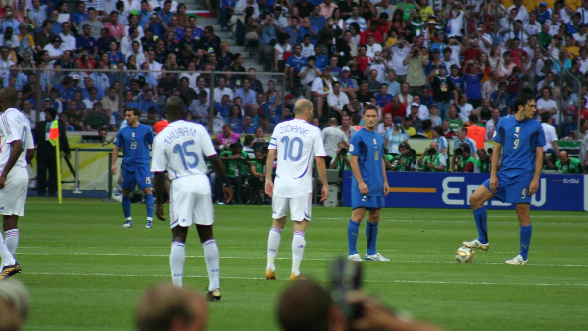 Joueurs de la France en blanc et de l’Italie en bleu sur le terrain devant les tribunes