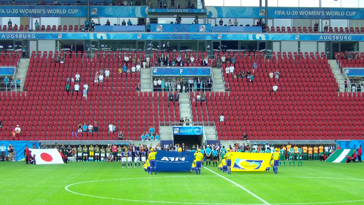 Selecciones femeninas sub-20 de Japón y Nigeria alineadas en el campo ante gradas rojas