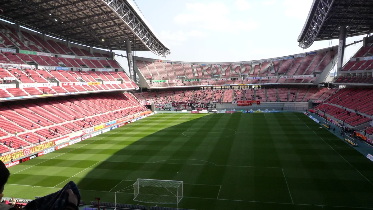 Interior do Toyota Stadium com gramado, gol, cobertura e arquibancadas vermelhas