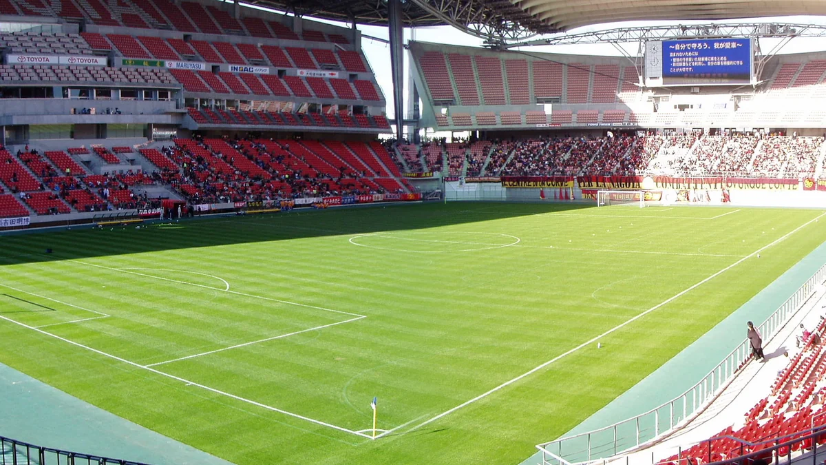 Campo de futebol do Toyota Stadium com arquibancadas vermelhas e parte do público