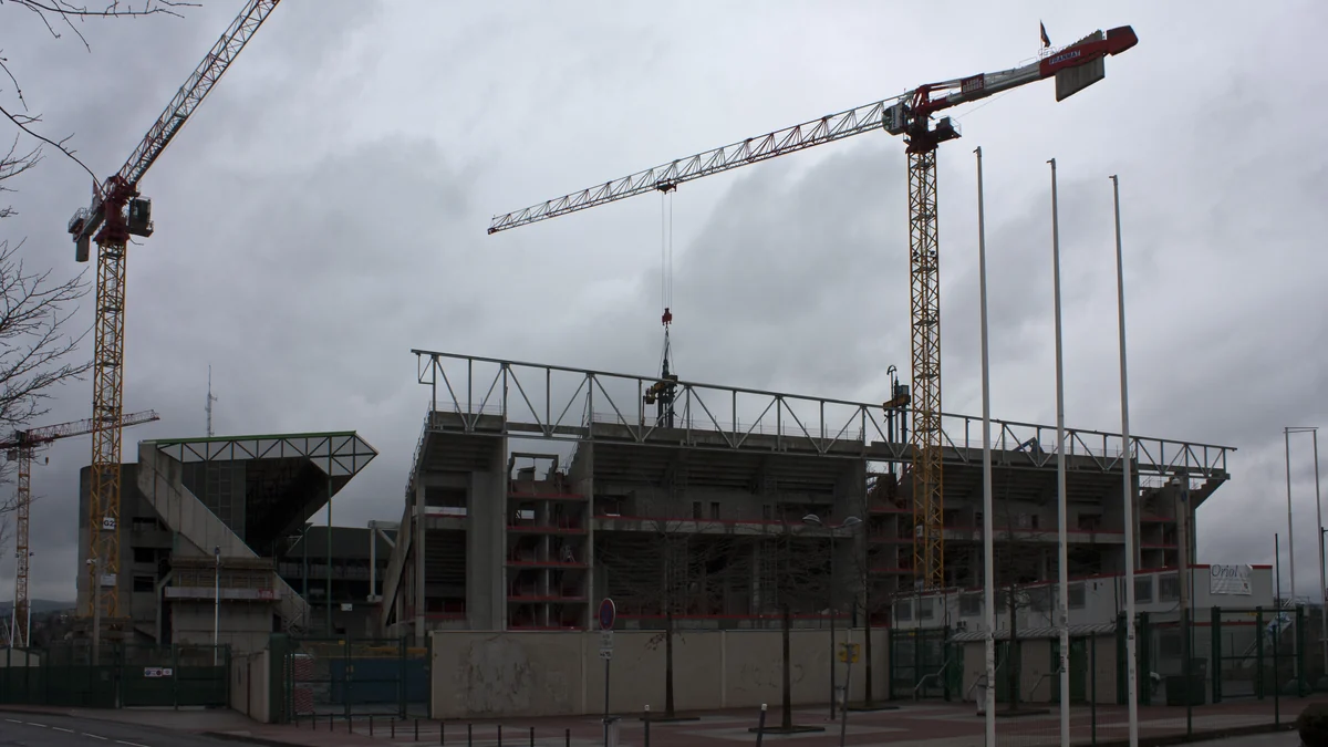 Estrutura do Geoffroy-Guichard em obras sob vários guindastes e céu nublado