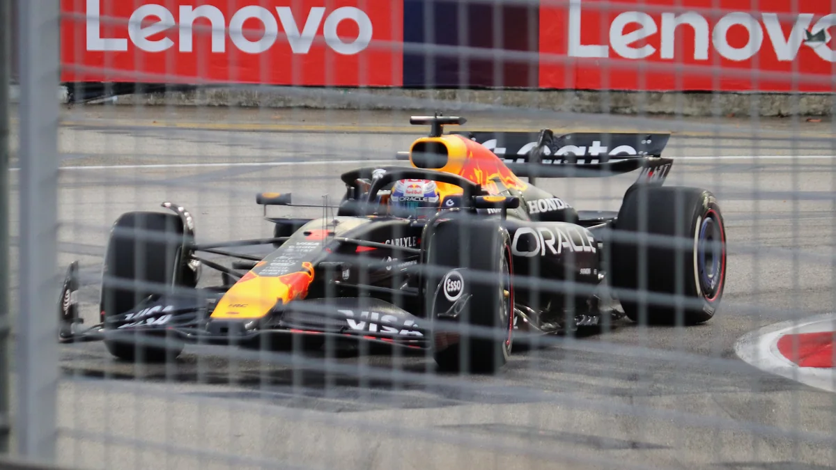 Red Bull de Max Verstappen contorna uma curva atrás da grade de proteção em Singapura.
