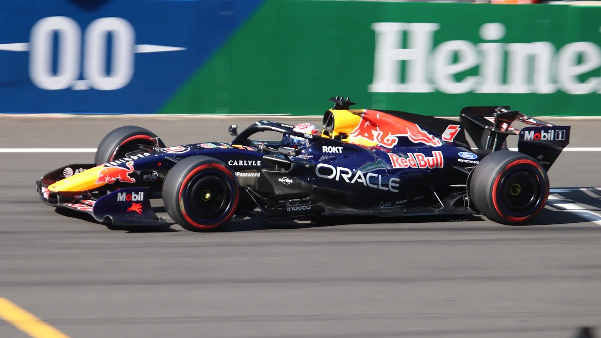 Max Verstappen’s Red Bull crosses a kerb in a side-on view.