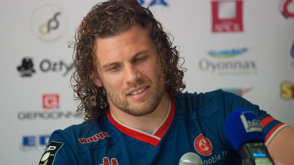 Fabien Alexandre, com a camisa azul do FC Grenoble, diante de microfones