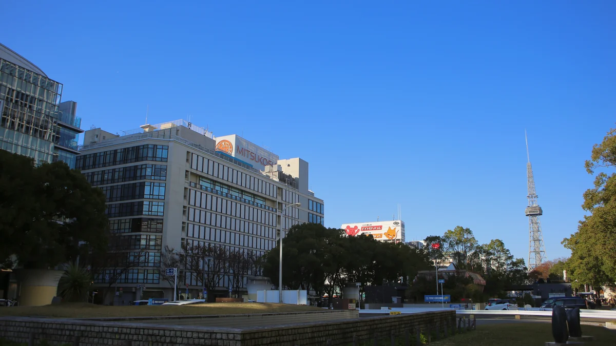 Buildings, trees and a tower beneath a blue sky in the Ai-no-hiroba area of Hisaya-odori Park