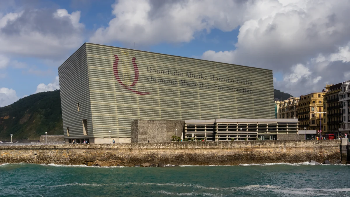 Bâtiment du Kursaal au bord de la mer, avec une colline et des immeubles en arrière-plan