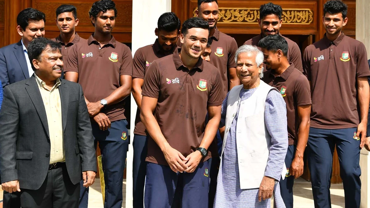 Jogadores de críquete de Bangladesh, com camisas marrons da seleção, posam ao lado de dois homens diante de um edifício.