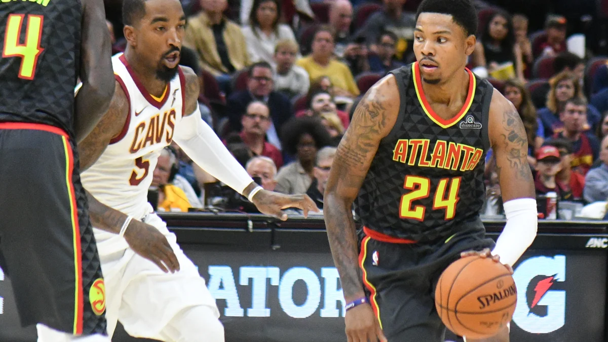 Jogador do Atlanta Hawks conduz a bola diante de um atleta do Cleveland Cavaliers