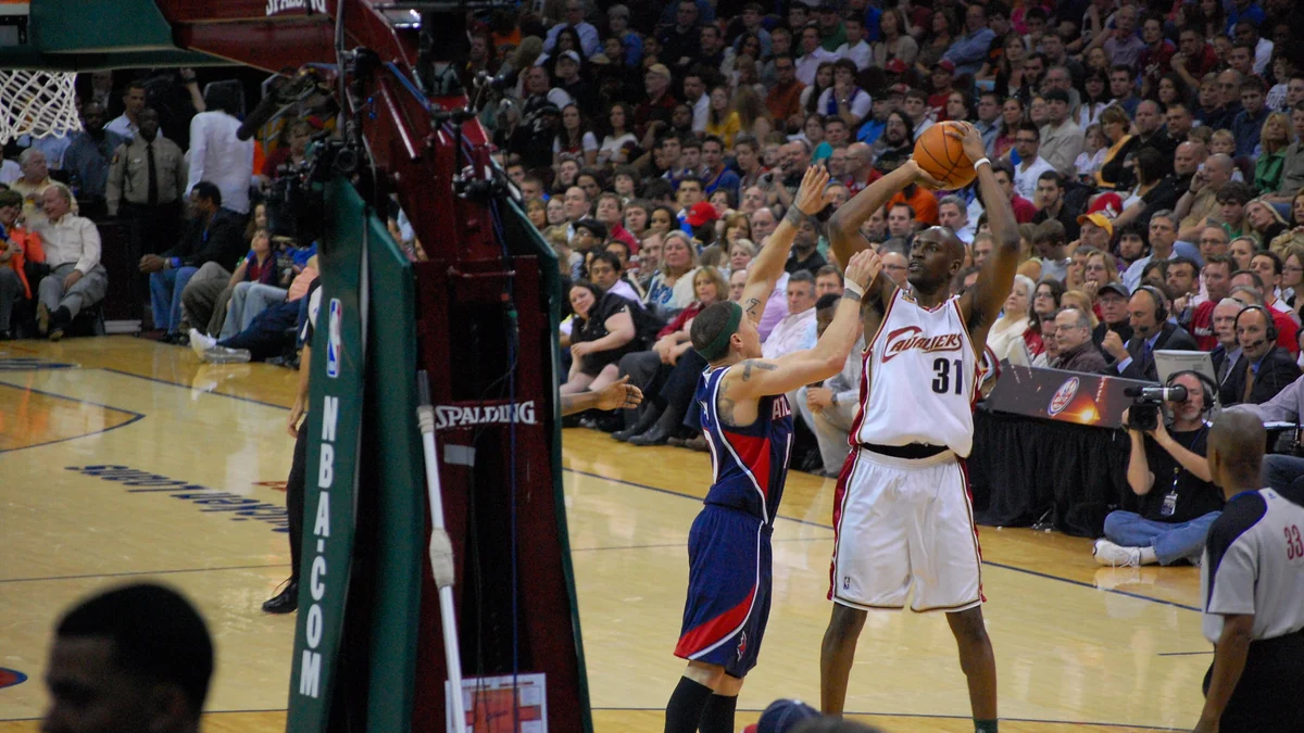 Jogador do Cleveland Cavaliers arremessa diante de um defensor do Atlanta Hawks perto da cesta