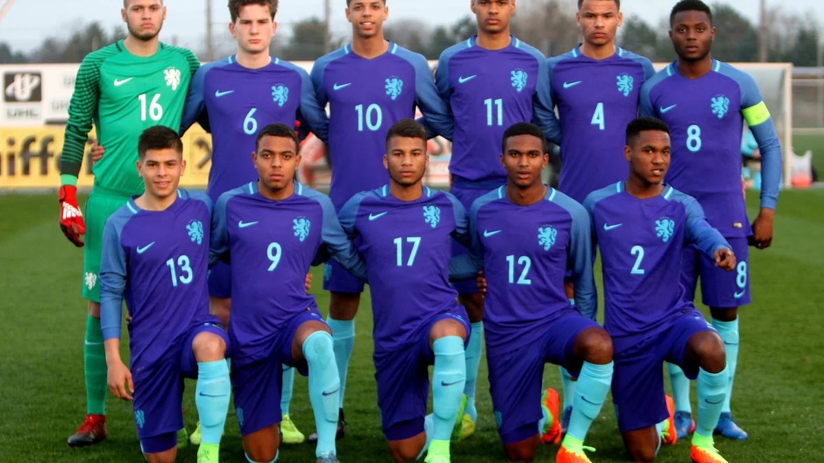 Eleven Netherlands youth players pose in two rows on the pitch