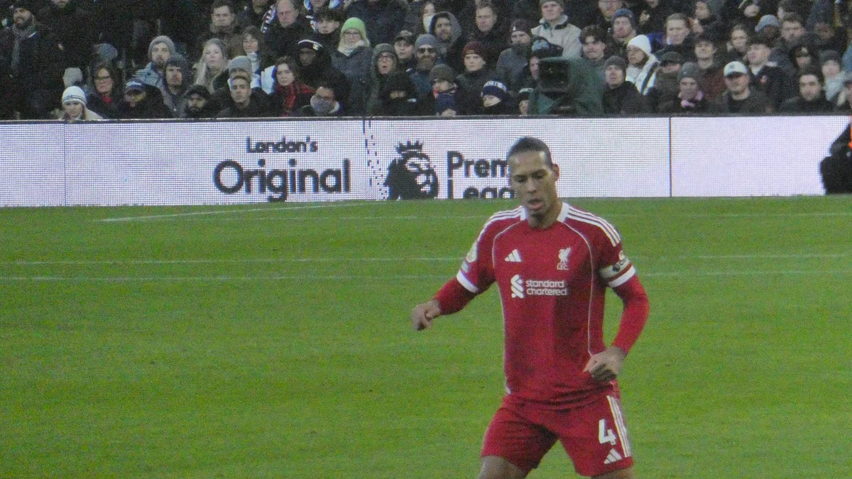 Virgil van Dijk corre no gramado com o uniforme vermelho do Liverpool