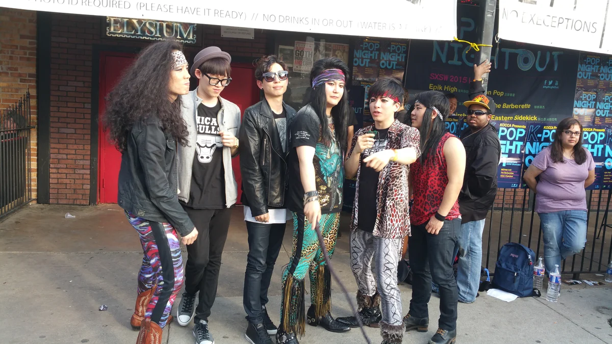 Six membres de groupes devant des affiches du K-Pop Night Out