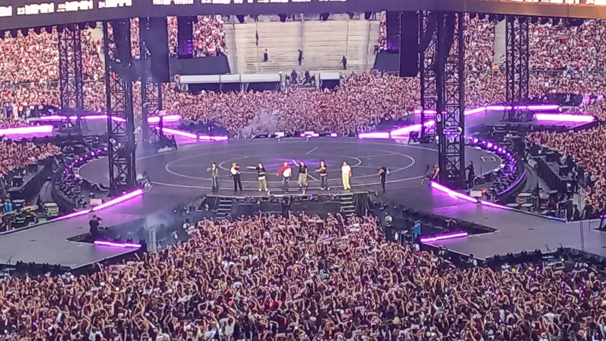 BTS actúa en un escenario circular ante un gran público en un estadio