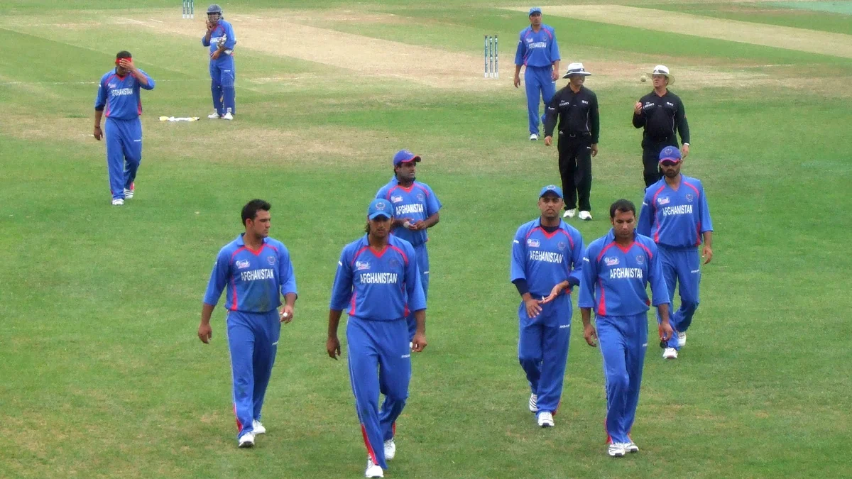 Afghanistan national team players walk across the field in blue uniforms