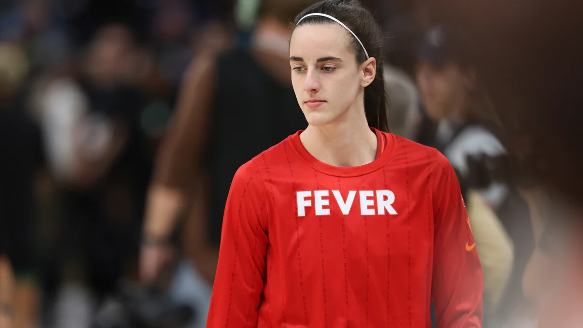 Indiana Fever player standing on the court in a red long-sleeved shirt.