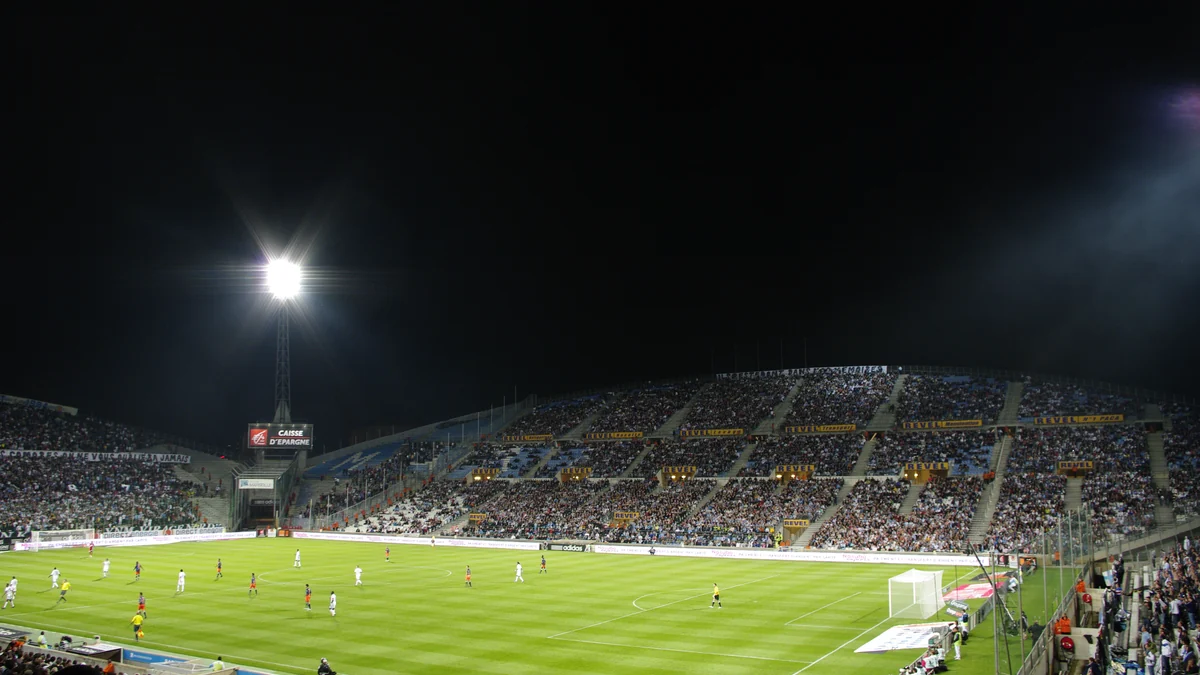 Vista ampla de um estádio à noite durante uma partida de futebol