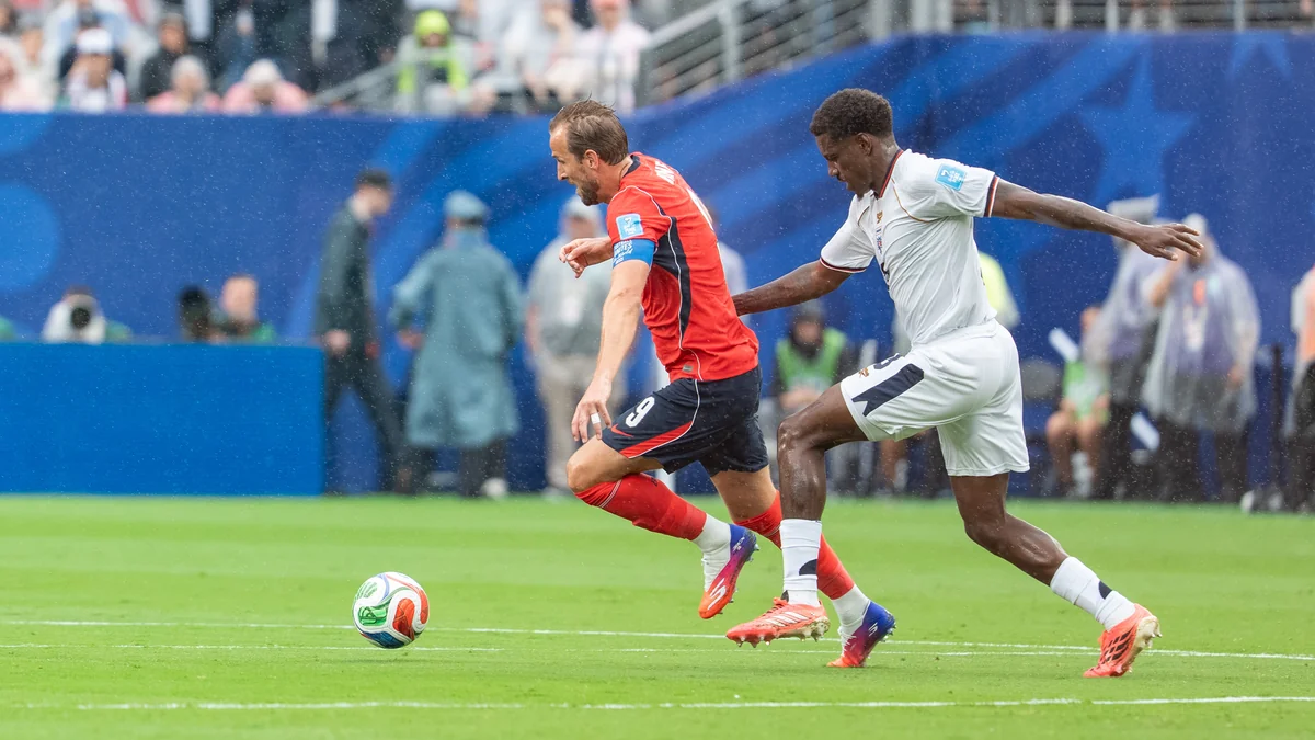 Harry Kane conduit le ballon sous la poursuite d’un adversaire.