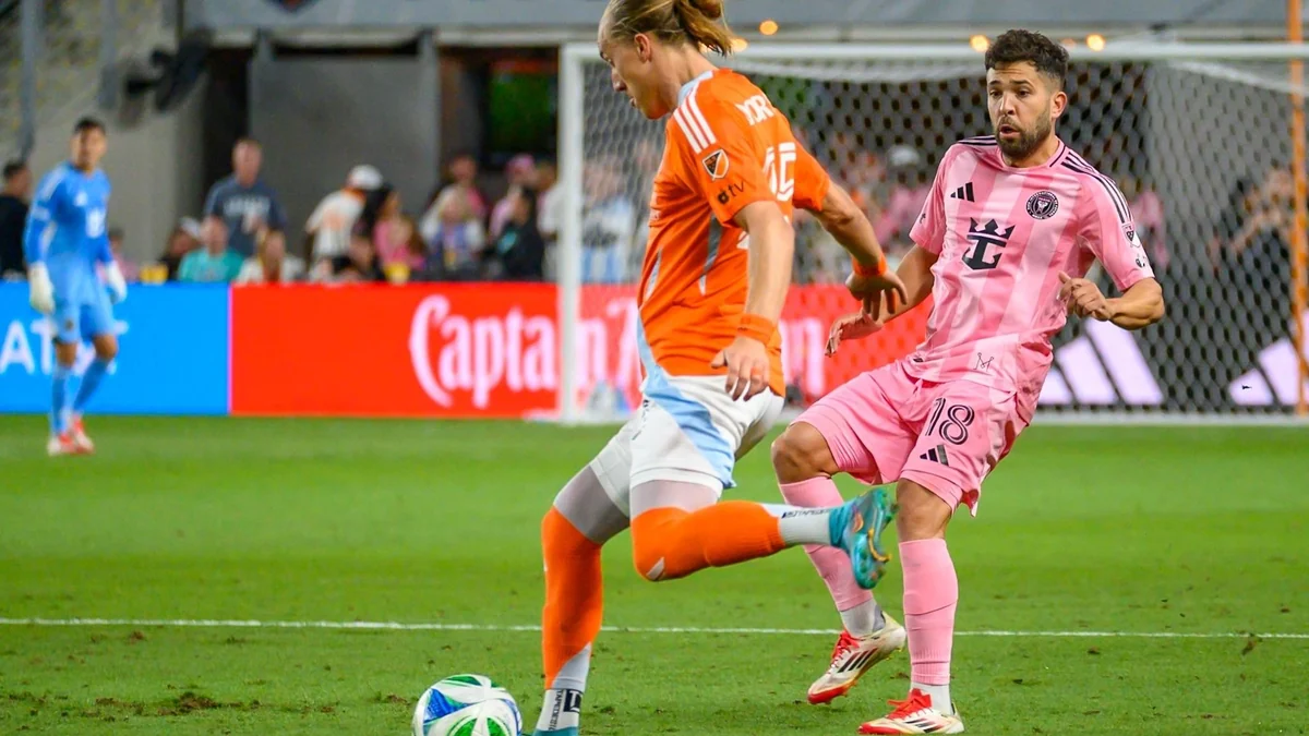 Jugador del Inter Miami con uniforme rosa disputa el balón con un rival de naranja