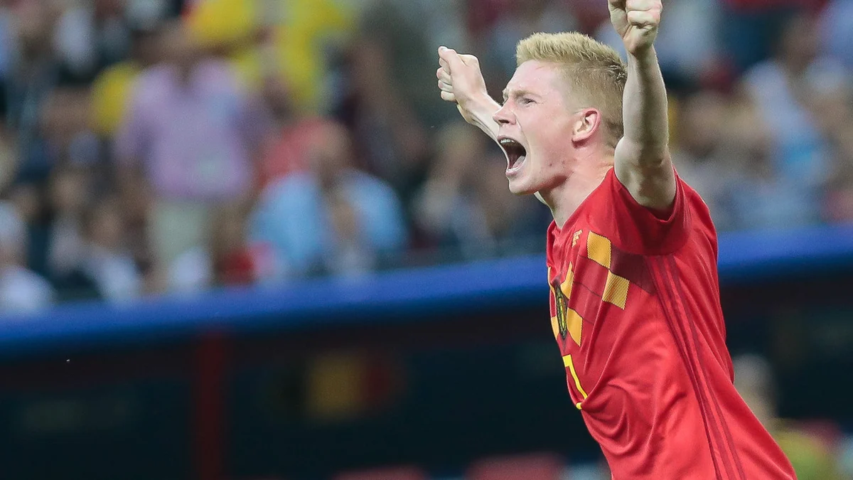 Kevin De Bruyne celebrates with both arms raised while wearing Belgium’s red shirt
