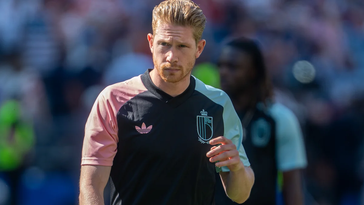 Kevin De Bruyne wearing Belgium’s black, pink and pale-blue shirt while holding a bottle
