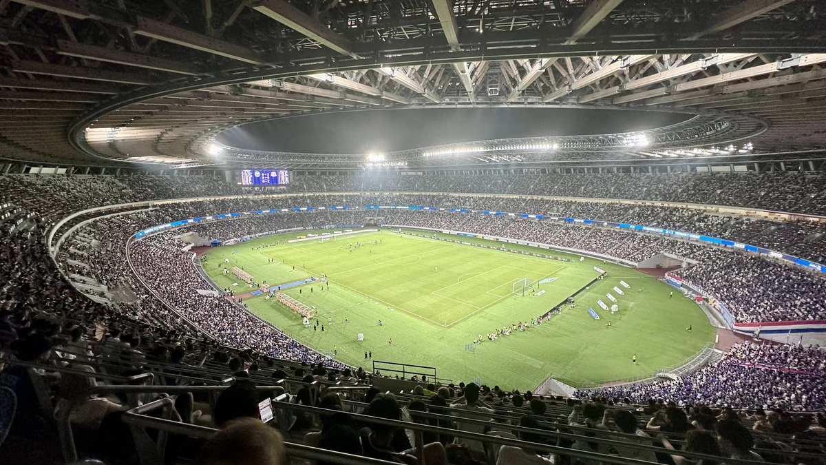 Estadio Nacional de Japón iluminado de noche, con el campo y las gradas vistos desde arriba
