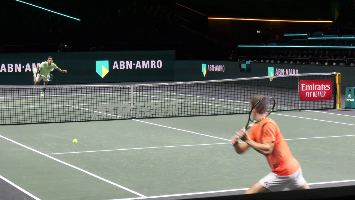 Jiri Lehecka, en maillot orange, prépare un retour sur un court de tennis couvert
