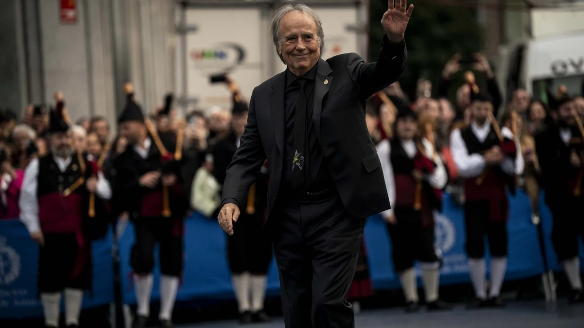 Joan Manuel Serrat dressed in black and waving to the crowd