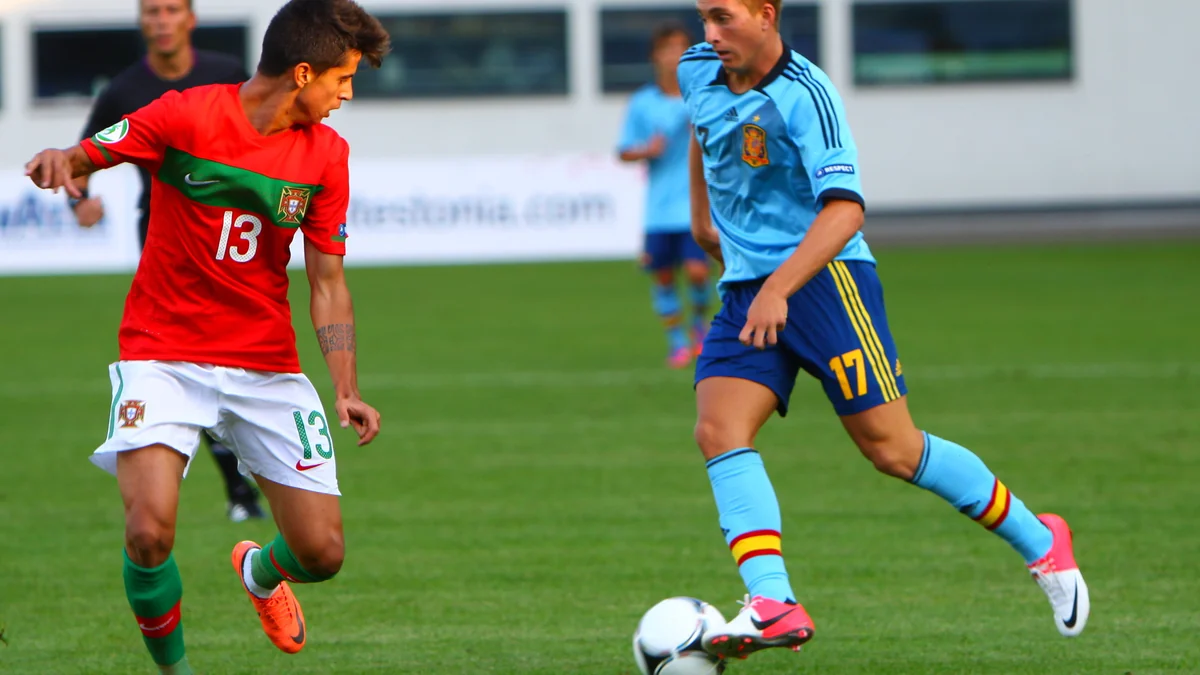 João Cancelo, com a camisa 13 de Portugal, conduz a bola diante de um jogador da Espanha
