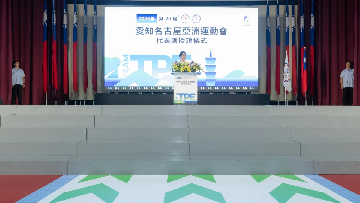 Stage with a speaker at a lectern in front of a screen about the 2026 Aichi-Nagoya Asian Games.