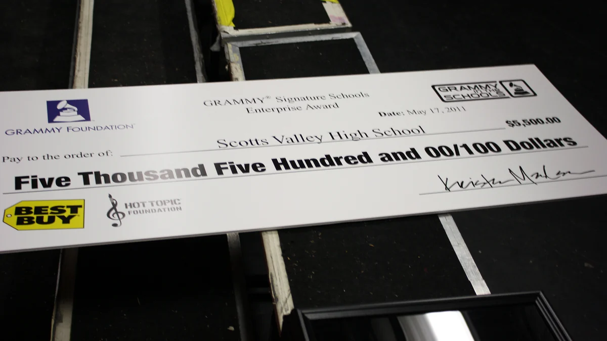 Ceremonial Grammy Foundation check resting on stage equipment