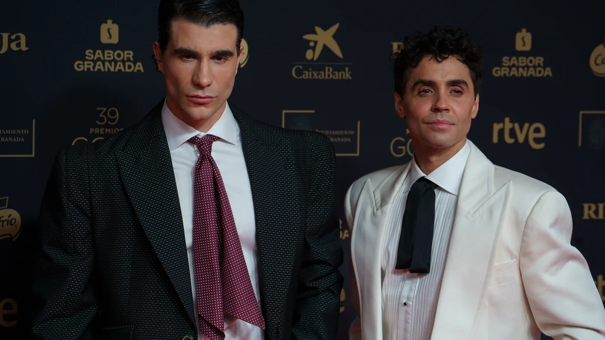 Javier Ambrossi and Javier Calvo in suits on a red carpet